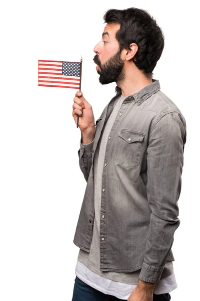 Hombre guapo con barba sosteniendo una bandera americana sobre fondo blanco —  Fotos de Stock
