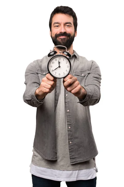 Handsome man with beard holding vintage clock on white backgroun — Stock Photo, Image