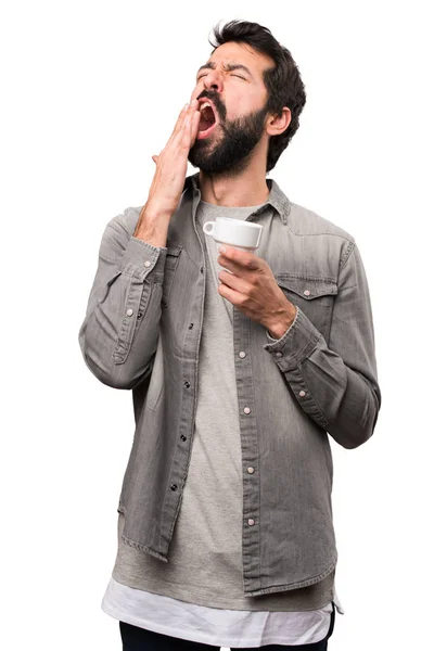 Jóképű férfi szakállal gazdaság egy csésze kávét a fehér backgro — Stock Fotó