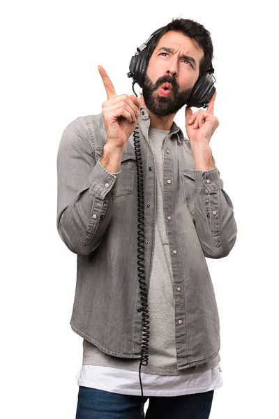 Hombre guapo con barba escuchando música sobre fondo blanco —  Fotos de Stock