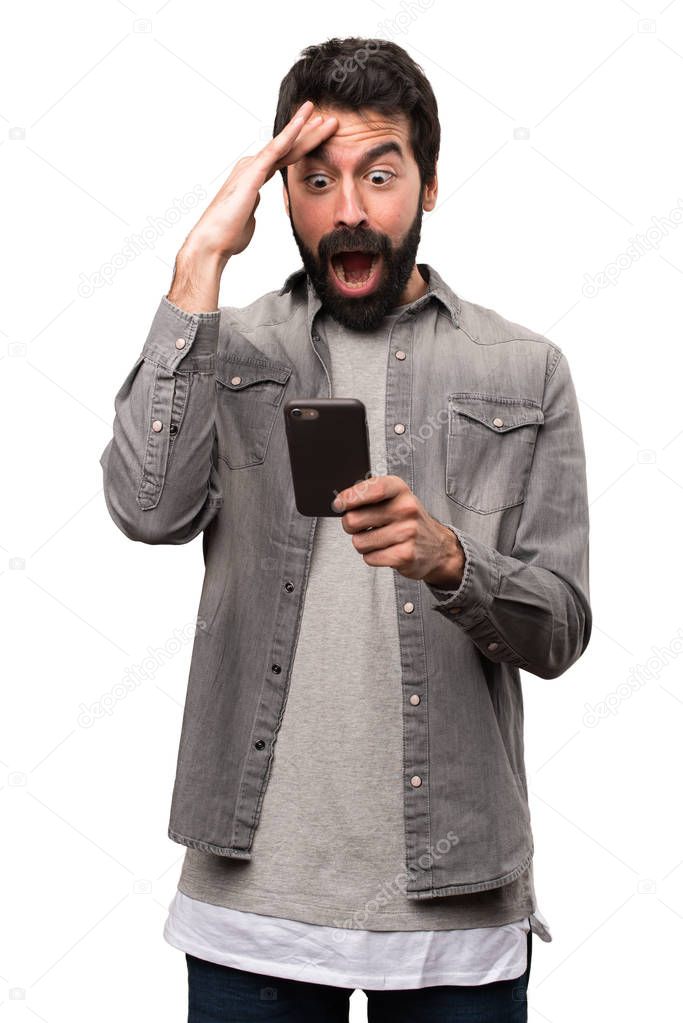 Surprised Handsome man with beard talking to mobile on white bac