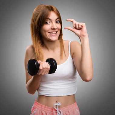 Güzel spor kadın küçük yapma dumbbells ile oturum üzerinde gri ba