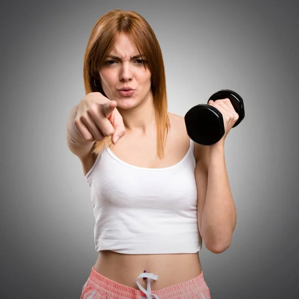 Hermosa mujer deportiva con mancuernas gritando sobre fondo gris — Foto de Stock