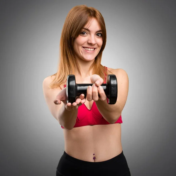 Feliz hermosa mujer del deporte con mancuernas sobre fondo gris — Foto de Stock