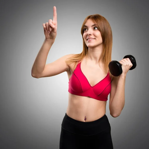 Hermosa mujer deportiva con mancuernas tocando en scr transparente — Foto de Stock