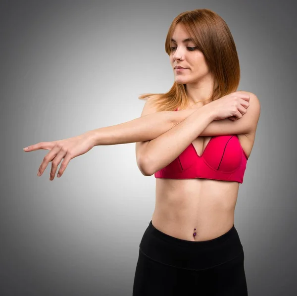 Sport kvinna stretching på grå bakgrund — Stockfoto