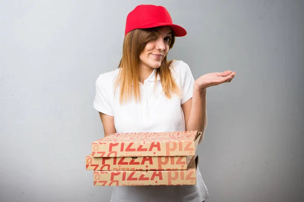 Mujer de entrega de pizza haciendo gesto sin importancia en la espalda texturizada — Foto de Stock