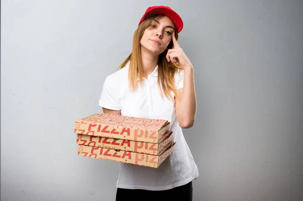 Mujer de entrega de pizza pensando en fondo texturizado — Foto de Stock