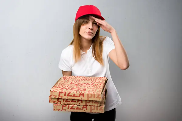 Πίτσα παράδοση γυναίκα δείχνει κάτι σε φόντο με υφή — Φωτογραφία Αρχείου