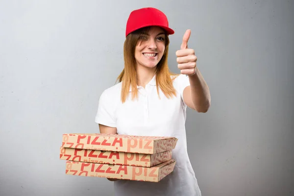 Πίτσα παράδοση γυναίκα με τον αντίχειρα επάνω σε φόντο με υφή — Φωτογραφία Αρχείου