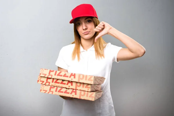 Mujer de entrega de pizza haciendo mala señal sobre fondo texturizado — Foto de Stock