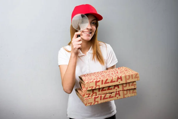 Mujer de entrega de pizza con lupa sobre fondo texturizado — Foto de Stock