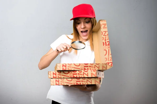Доставка пиццы женщина с увеличительным стеклом на текстурированной backgroun — стоковое фото