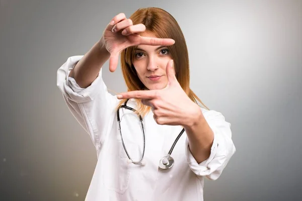 Fiatal orvos nő összpontosítva az ujjait, a szürke háttér — Stock Fotó