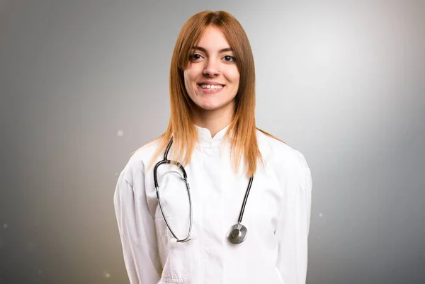 Щаслива молода лікарка на сірому фоні — стокове фото