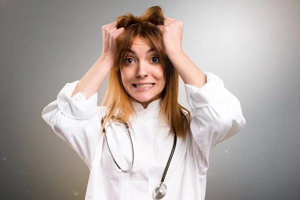 Frustrerade unga läkare kvinna på grå bakgrund — Stockfoto