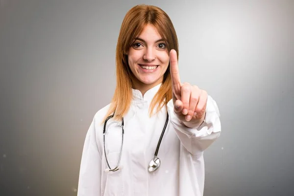 Jonge dokter vrouw tellen op grijze achtergrond — Stockfoto