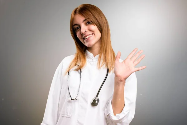 Молода лікарка, солона жінка на сірому фоні — стокове фото