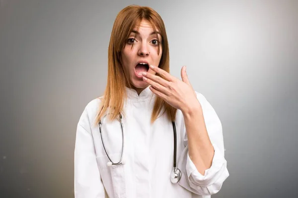 Ung läkare kvinna gör överraskning gest på grå bakgrund — Stockfoto
