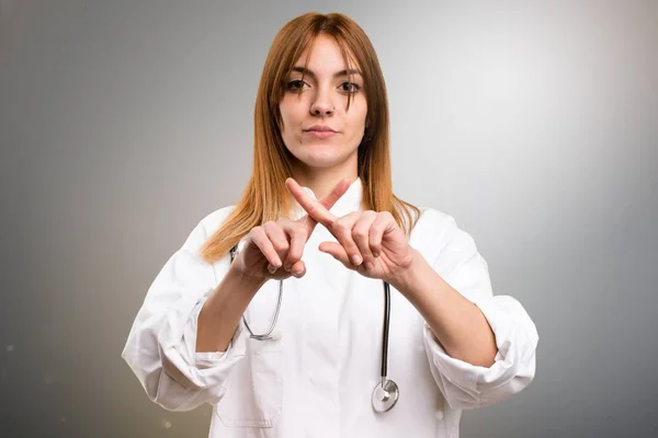 Fiatal orvos nő, ami nem a gesztus, a szürke háttér — Stock Fotó