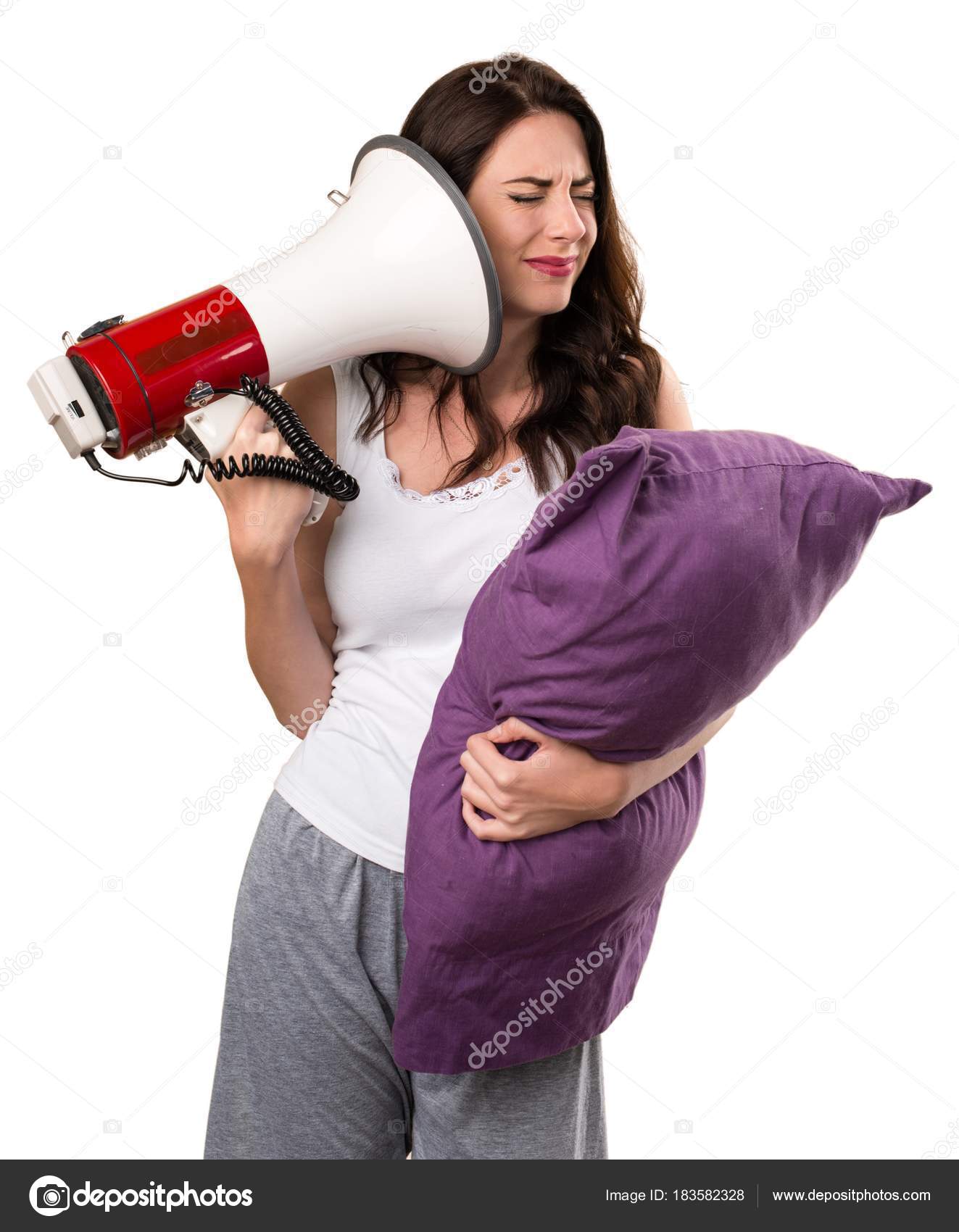Beautiful young girl with a pillow holding a megaphone Stock Photo by