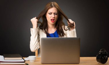 Onu laptop ile siyah arka plan üzerine çalışan sinirli iş kadın