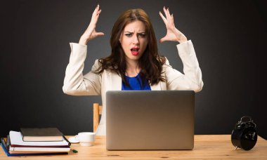 Onu laptop ile siyah arka plan üzerine çalışan sinirli iş kadın