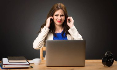 Onu laptop ile çalışma ve kulakları siyah arka plan üzerine kapsayan iş kadını