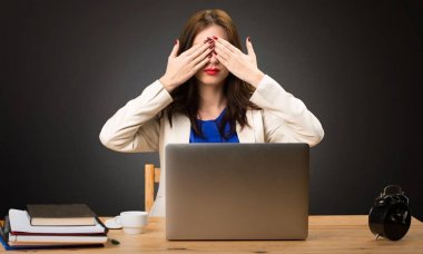 Onu laptop ile çalışma ve gözleri siyah arka plan üzerine kapsayan iş kadını