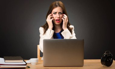 Onu laptop ile siyah arka plan üzerine çalışan korkmuş iş kadın