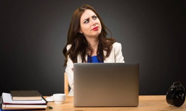 Onu laptop ile çalışma ve siyah arka plan üzerine düşünme iş kadını