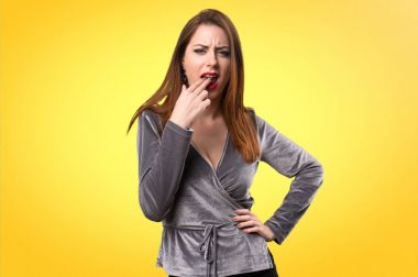 Güzel genç kız renkli arka plan üzerinde kusma jest yapma