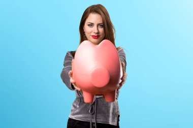 Renkli arka plan üzerinde bir servet tutan güzel genç kız