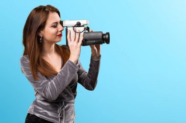 Beautiful young girl filming on colorful background clipart