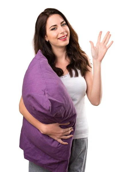 Hermosa joven con una almohada saludando — Foto de Stock