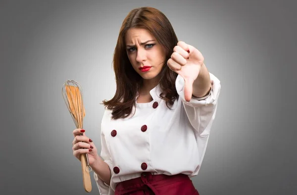 Vackra kock kvinna att göra dålig signal på grå bakgrund — Stockfoto