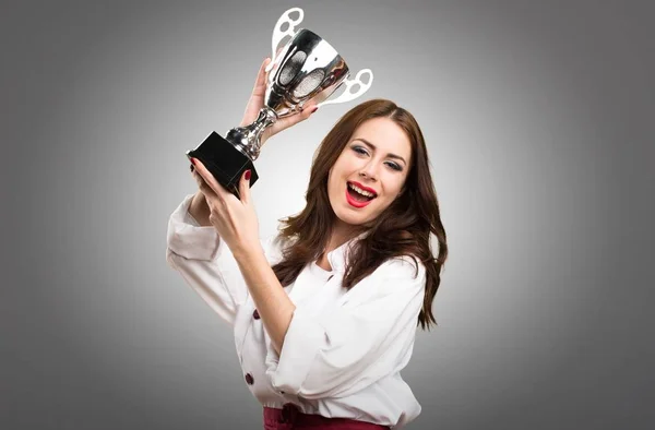 Bella chef donna in possesso di un trofeo su sfondo grigio — Foto Stock
