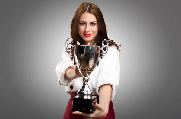 Mulher chef bonita segurando um troféu no fundo cinza — Fotografia de Stock