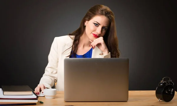 Zakenvrouw werken met haar laptop op zwarte achtergrond — Stockfoto