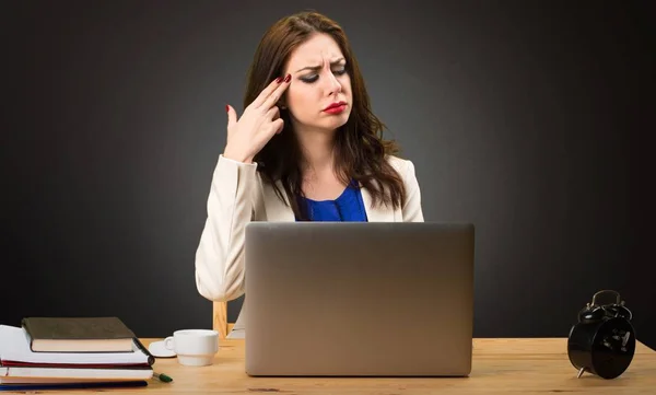Affärskvinna arbetar med sin laptop och gör självmord gest på svart bakgrund — Stockfoto