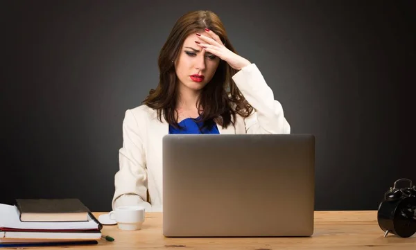 Frustrated business woman working with her laptop on black background