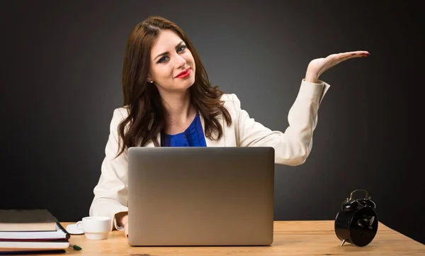 Affärskvinna arbetar med sin laptop och hålla något på svart bakgrund — Stockfoto