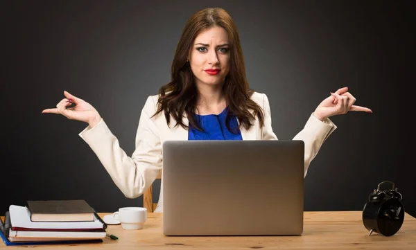Zakenvrouw werken met haar laptop en wordt gewezen op de laterals twijfels op zwarte achtergrond — Stockfoto