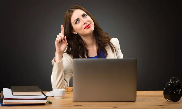 Affärskvinna arbetar med sin laptop och pekar uppåt på svart bakgrund — Stockfoto