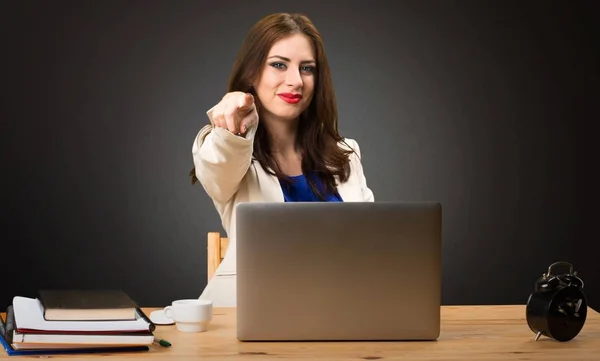 Obchodní žena pracující s laptopem a ukazoval na frontu na černém pozadí — Stock fotografie