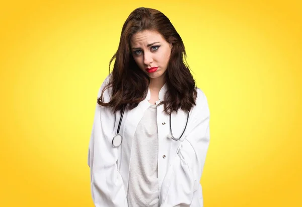 Triste medico donna su sfondo giallo — Foto Stock