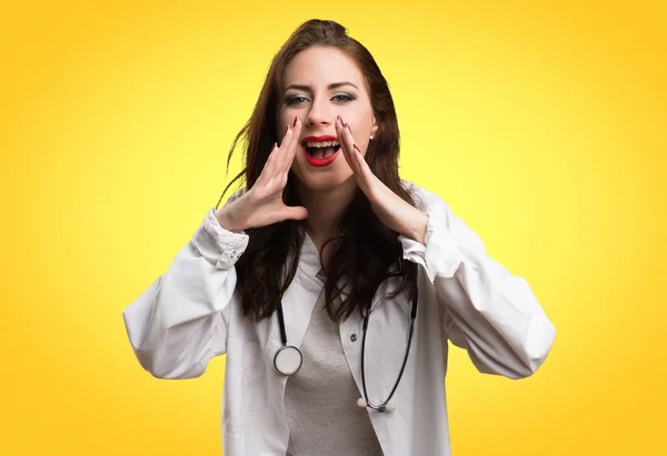 Женщина-врач кричит на желтом фоне — стоковое фото