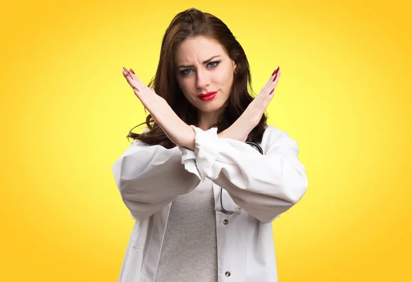 Doktor žena dělat žádné gesto na žlutém podkladu — Stock fotografie