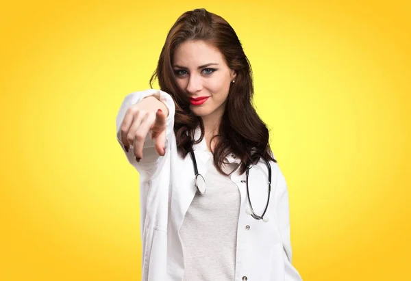 Läkare-kvinna som pekar på framsidan på gul bakgrund — Stockfoto