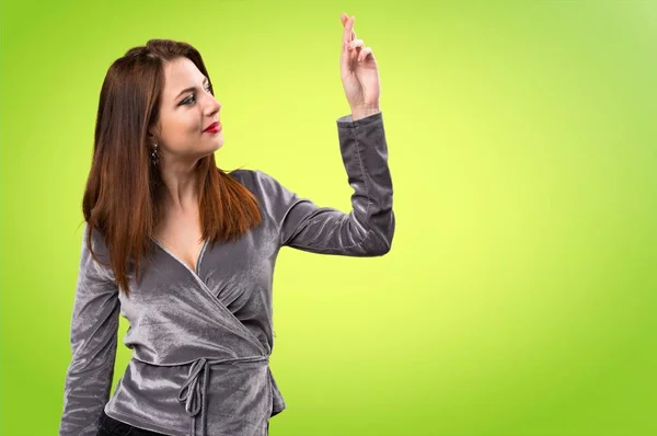 Mooi jong meisje met haar vingers oversteken op kleurrijke achtergrond — Stockfoto